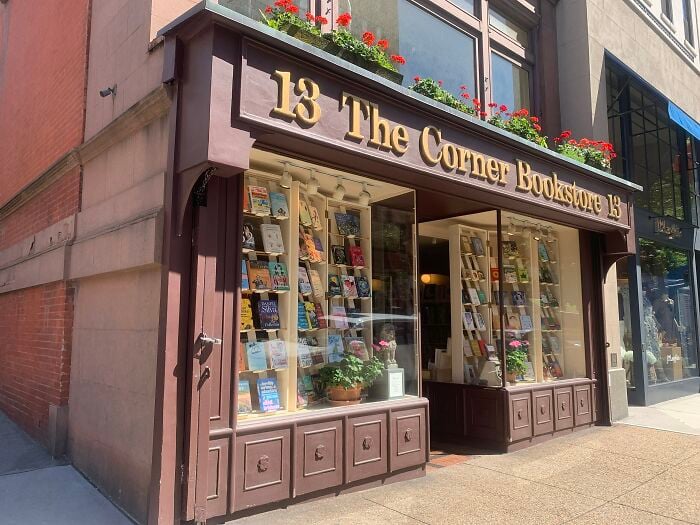 Reizende Buchhandlungfassade mit Blumenk&auml;sten, die eine gem&uuml;tliche und magische Buchhandlung aus aller Welt zeigt.
